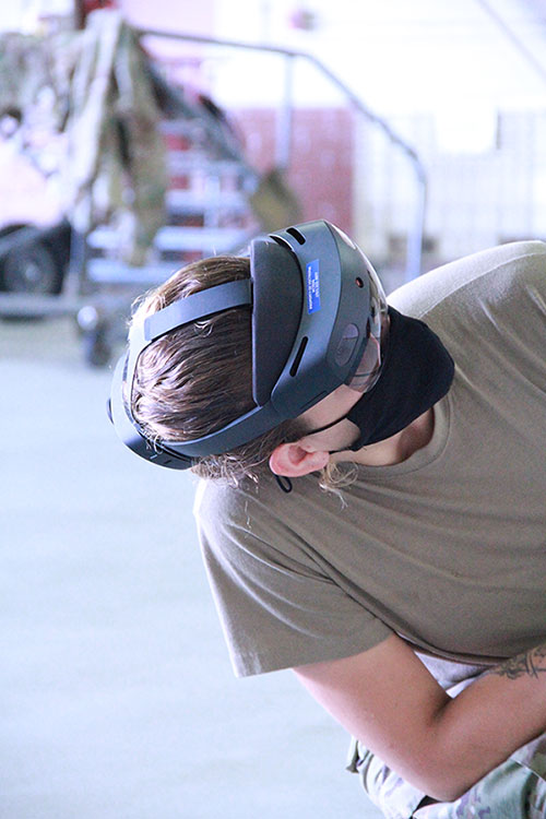 Air Force Senior Airmen performing maintenance training using mixed-reality experiences.